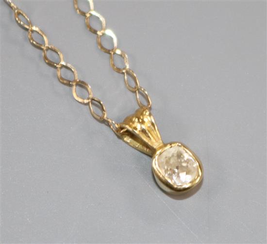 A yellow metal and solitaire diamond pendant, on a 9ct gold chain.